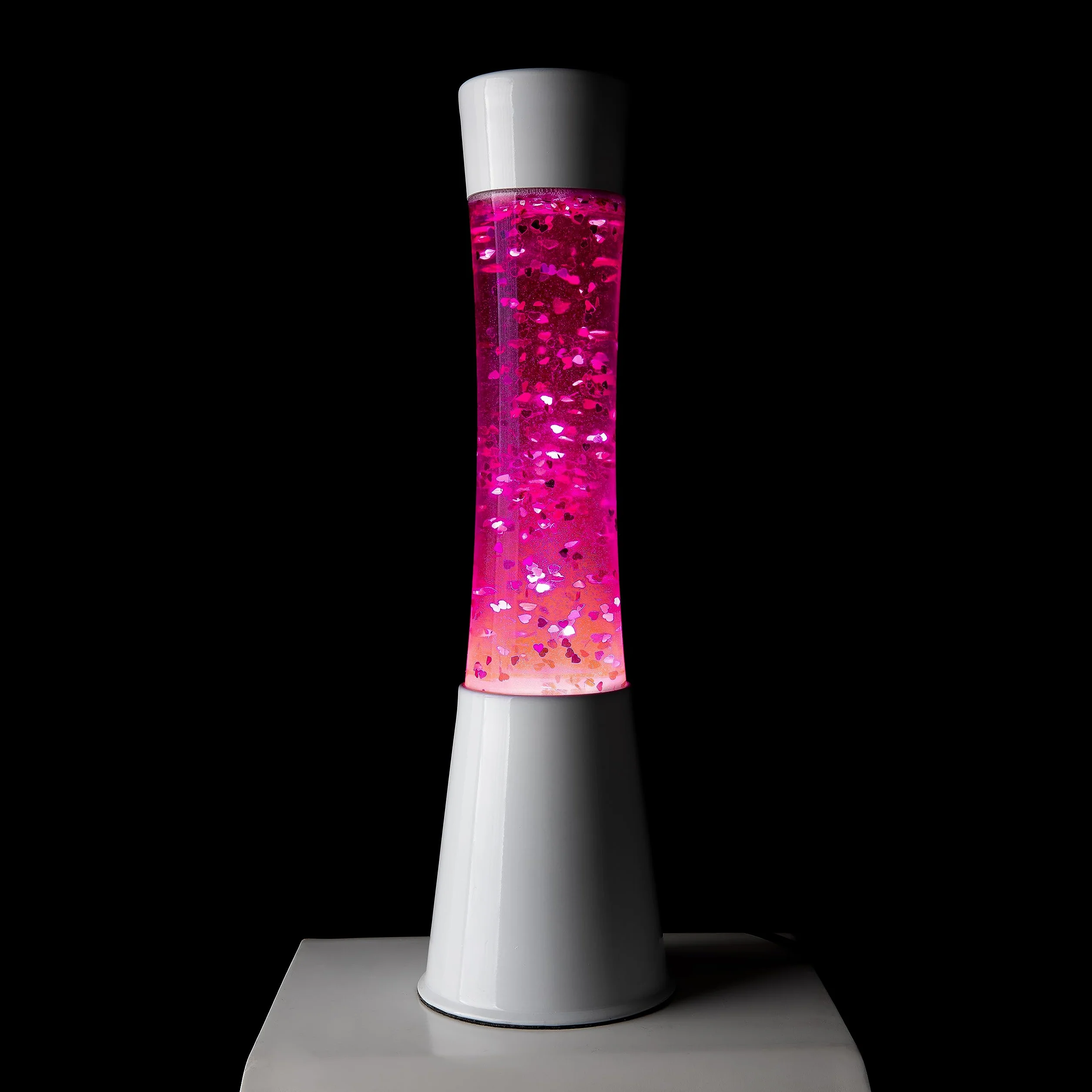 Fisura - Lámpara de lava rosa. Base blanca, líquido rosa y purpurina de corazones. Lámpara efecto relajante. Con bombilla de repuesto. 11 cm x 11cm x 39,5 cm.