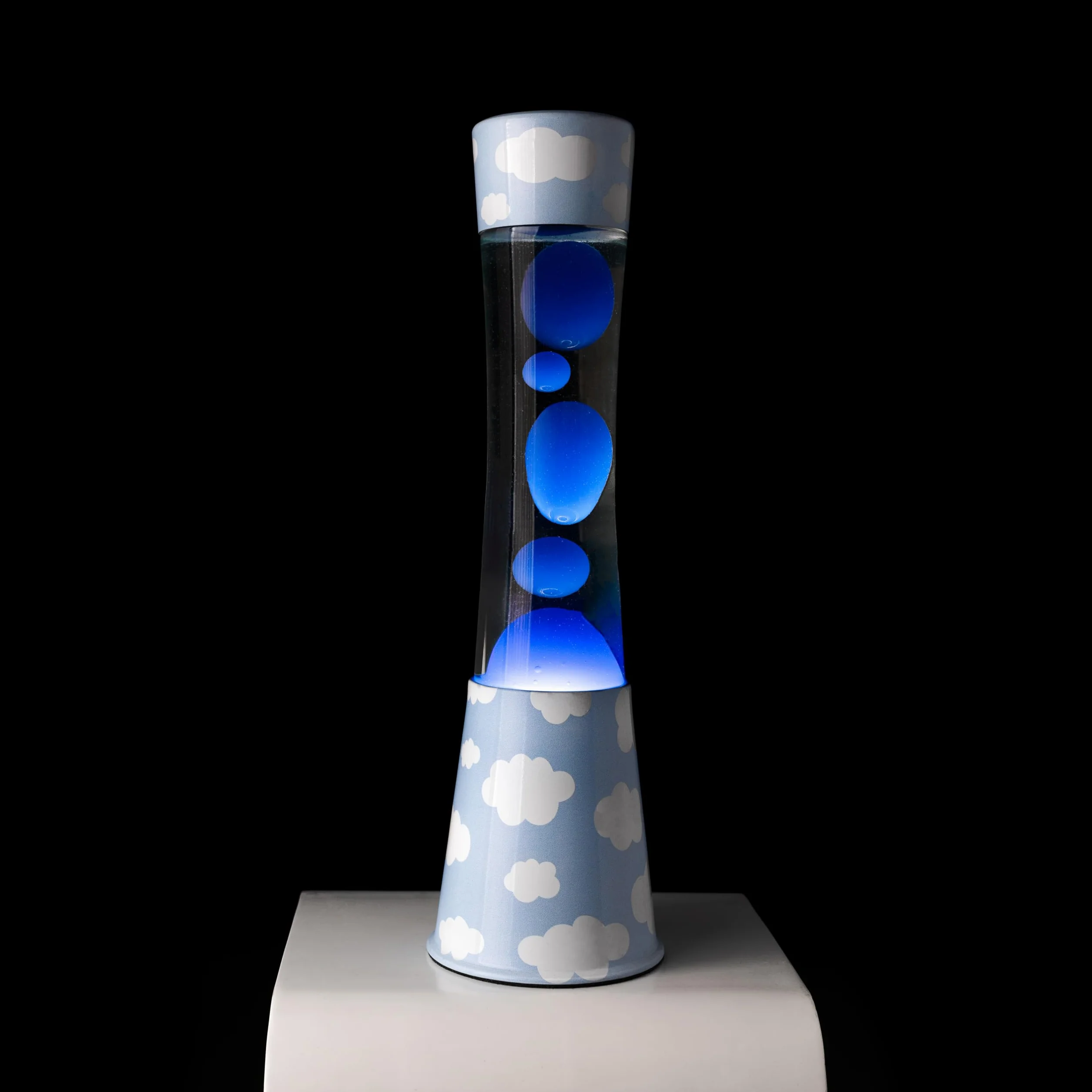 Fisura - Lámpara de lava "nubes". Base con estampado de nubes, líquido transparente y lava azul. Lámpara efecto relajante. Con bombilla de repuesto. 11 cm x 11cm x 39,5 cm.