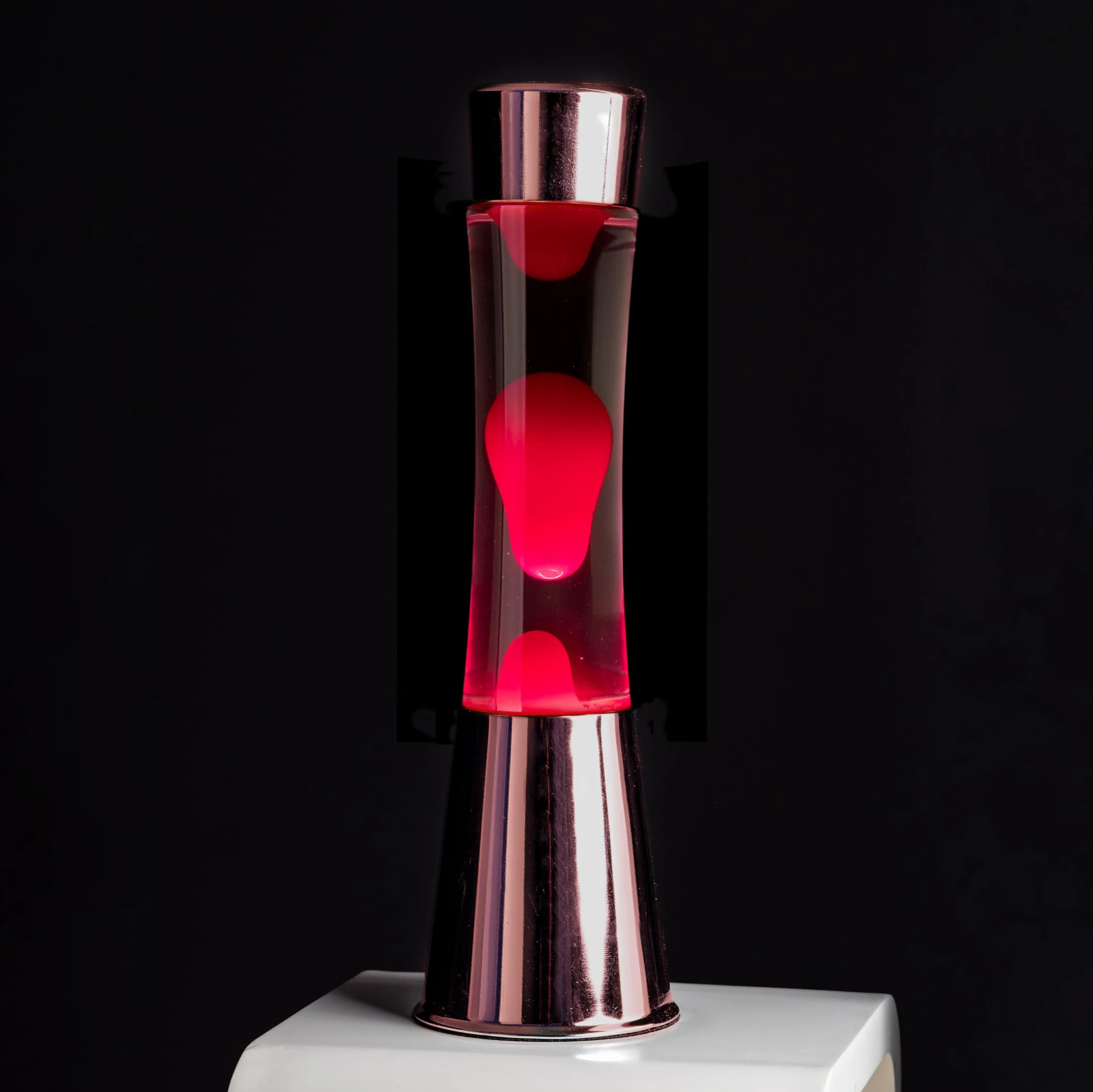 Fisura - Lámpara de lava rosa. Base cromada oro rosa, líquido transparente y lava. Lámpara efecto relajante. Con bombilla de repuesto. 11 cm x 11cm x 39,5 cm